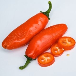 Orange Spice Jalapeno, whole and sliced on light background.