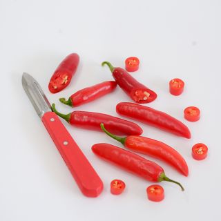 Serrano Tampequino Peppers sliced on white background.