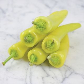 Hungarian Hot Wax Peppers stack on marble countertop
