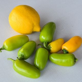 Lemon Spice Jalapeno peppers in yellow and green, with lemon.