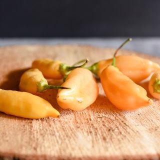Sugar Rush Peach Peppers on wooden plank.