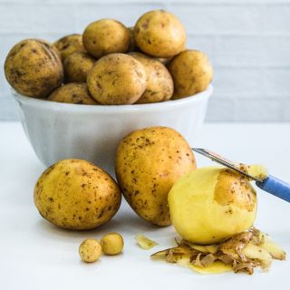 Mature Yukon Gold Potatoes grown from Yukon Gold Micro Tuber Potatoes on a white background.