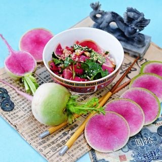 Chinese Red Meat Radish salad surrounded by radishes and slices.
