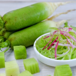 Chinese Shawo Fruit Radish sald with whole and cut radishes on a light background.