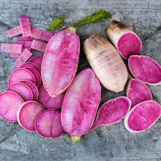 Sliced and whole Pusa Gulabi Radishes on a weathered metal background.