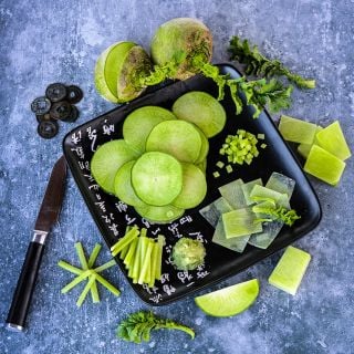Cut and whole Wasabi Radish arranged around a plate on a gray background.