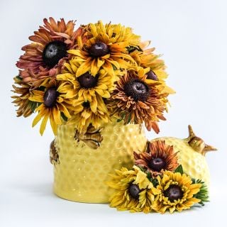 Caramel Rudbeckia Arranged in bee hive ceramic vase on white background.