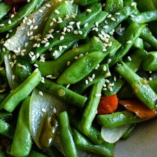 A close-up of cooked McCaslan 42 Pole Beans with sesame seeds.
