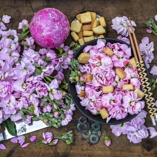 New Kabuki Light Pink Stocks blooms in salad with chop sticks on wooden table.