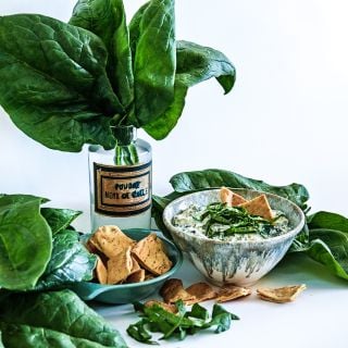 Monstrueux De Viroflay Spinach leaves with spinach dip and pita chips.