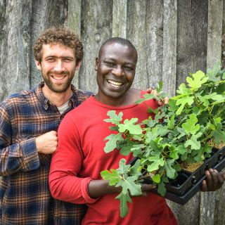 A Baker Creek employee and a MESA intern pose with some awesoe fig plants at the Spring Planting Festival.