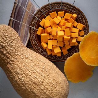 Butternut Rogosa Violina Gioia Winter Squash with chopped squash in a bowl.