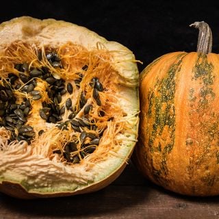 Cut and whole Lady Godiva Winter Squash with hulless seeds in the pumpkin.