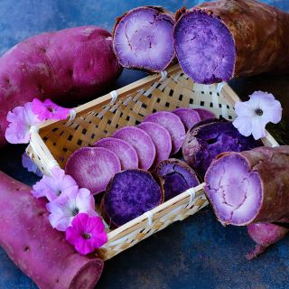 Backed Lilac Beauty Sweet Potatoes sliced in basket and fresh and baked with petunia flowers.