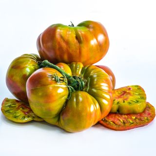 Large Ananas Noire or Black Pineapple Tomatoes with slices on a white background.