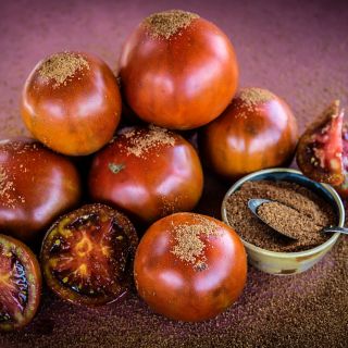Brown Sugar Tomatoes with brown sugar sprinkled on a deep red background.