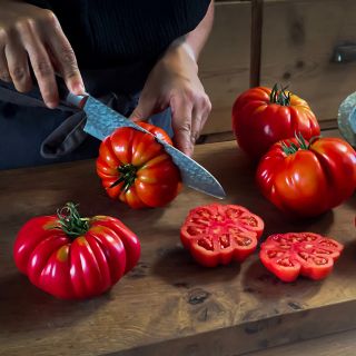 Woman cutting Mushroom Basket Tomatoes on wooden cutting board. IMage by Lucy Hutchins.
