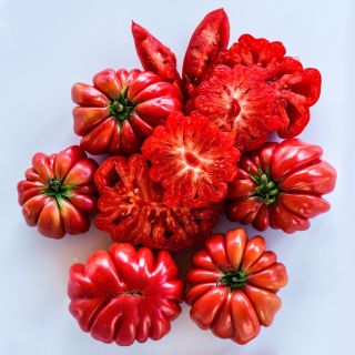 Overhead view of cut and whole Mushroom Bakset Tomatoes on white background.