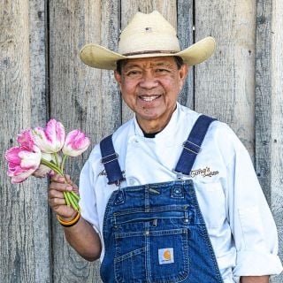 Chef Tong holding a posy of pink tulips at the Baker Creek Tulip Festival.
