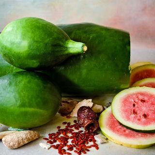 Whole and sliced Art Combe's Ancient Watermelon with red seeds.