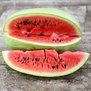 Charleston Gray Watermelon sliced on wooden background.